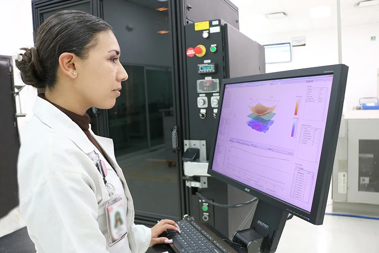 Employee studying graphical data on a computer screen.